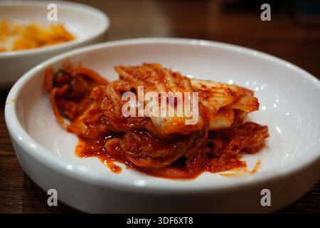 Scharfe koreanische Kimchi in einer weißen Schüssel, eine traditionelle fermentierte Beilage Stockfoto