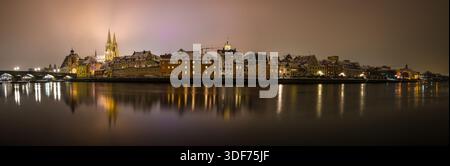 Regensburg, Bayern, Deutschland, 24. November 2025, Regensburg mit Blick auf den Petersdom und die Steinerne Brücke bei Nacht im Winter mit Schnee und Stockfoto