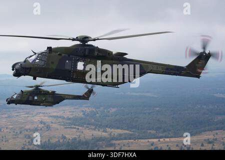 Luft-Luft-Formationsflug mit zwei NHIndustries NH90 Hubschraubern der Deutschen Armee während der NATO-Tage 2025. Die Abbildung zeigt die NH90 NFH-Registrierung 79+24, seriell 1031, die parallel zur NH90 TTH-Registrierung 78+27, seriell 1117 fliegt. Nahaufnahmen zeigen Cockpit-Details und Piloten in beiden Flugzeugen. Diese zweimotorigen, mittelgroßen Mehrzweckhubschrauber werden von Rolls-Royce Turbomeca RTM322-Turbomeca-Turbomeca-Turbomeca-Turbomeca-Turbomeca- Stockfoto