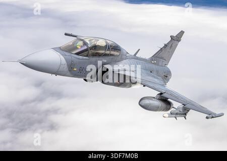Luft-Luft-Foto, das eine tschechische Luftwaffe Saab JAS 39D Gripen während des Fluges während der NATO-Tage 2025 zeigt. Das Luftfahrzeug trägt die Eintragungsnummer 9819 und die Seriennummer 39819. Das Bild konzentriert sich auf eine Nahansicht des Cockpits, bei der der Pilot während des Fluges sichtbar ist. Der JAS 39D ist eine zweisitzige Gripen-Variante, die für Training und Umbau verwendet wird und gleichzeitig die volle Kampffähigkeit behält. Er verfügt über einen Dreiecksflügel, Canards und einen Volvo RM12 Turbofan-Motor für Multifunktionsleistung. Stockfoto