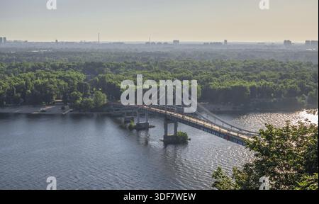 Kiew, Ukraine 07.11.2020. Blick von oben auf die Fußgängerbrücke über den Fluss Dnieper an einem sonnigen Sommermorgen, Kiew, Ukraine Stockfoto