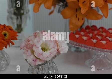 Nahaufnahme von Blumen und Süßigkeiten auf dem Tisch Stockfoto