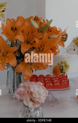 Nahaufnahme von Orangenlililien und Desserttisch Stockfoto