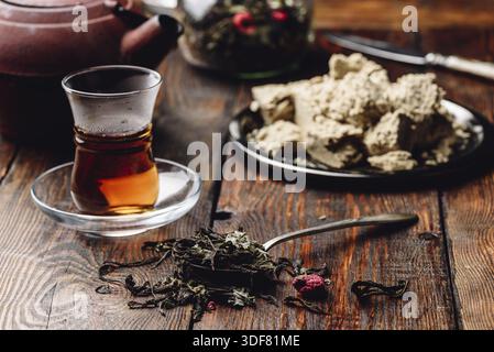 Esslöffel himbeere Kräutertee und bereit, Tee in armudu Glas mit Platte von Sonnenblume halva Stockfoto