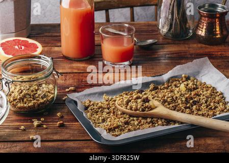 Gebackenes Müsli zum Frühstück mit Saft aus Pampelmusen oder Grapefruits Stockfoto