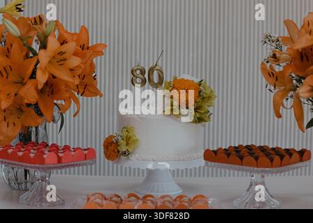 Eleganter Kuchen zum 80. Geburtstag mit Blumenarrangements Stockfoto