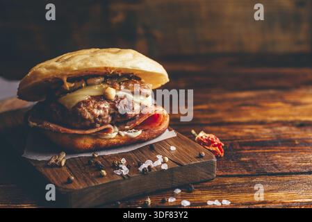 Hausgemachter Cheeseburger mit Rindfleisch auf hölzernem Hintergrund und Kopierraum Stockfoto