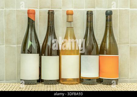 Foto, das eine Installation dokumentiert, in der gefüllte und versiegelte Weinflaschen an der Wand zu schweben scheinen und die Farbpalette von Bernstein t unterstreicht Stockfoto