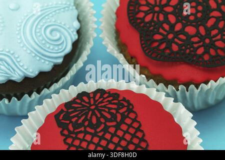 Detail der leckere handgemachte Cupcakes. zwei rot und blau auf blauem Hintergrund Stockfoto