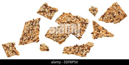 Fallende Knäckebäckstücke, gebrochene Vollkorncracker mit Leinsamen isoliert auf weißem Hintergrund Stockfoto