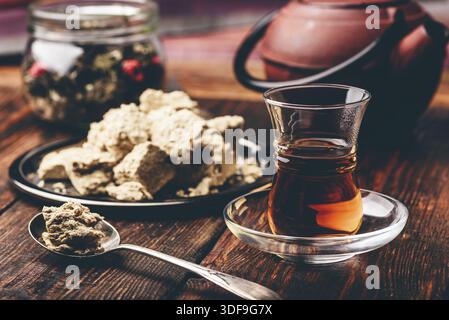 Schwarzer Tee in armudu Glas und Löffel Sonnenblumenöl halva Stockfoto