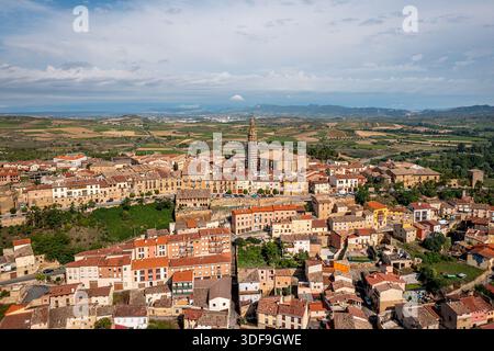 Panoramablick auf eine sonnendurchflutete spanische Stadt mit Terrakottadächern, einem hohen Kirchturm, Briones, La Rioja, Spanien Stockfoto