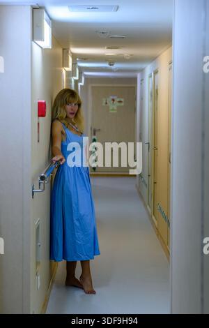 Elegante Frau in einem blauen Kleid in einem modernen russischen Flur bei Nacht Stockfoto
