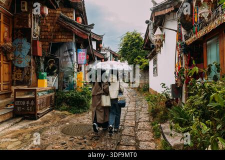Traditionelle Shuhe Storefront mit zwei Besuchern unter dem Regenschirm in der Historic Street Stockfoto