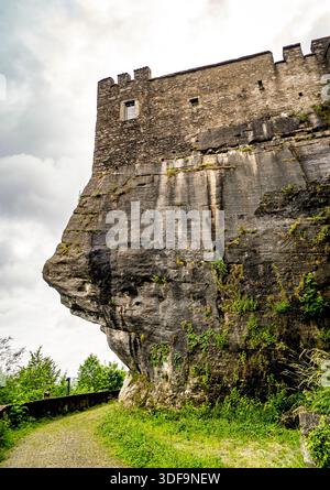 Alte Steinburg auf einer felsigen Klippe unter einem bewölkten Himmel. Stockfoto