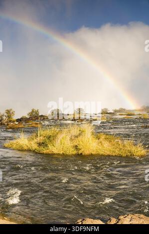 Regenbogen am frühen Morgen von der Sambia-Seite der Victoria Fälle gesehen Stockfoto