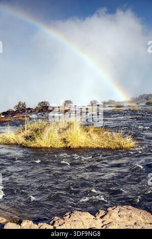 Regenbogen am frühen Morgen von der Sambia-Seite der Victoria Fälle gesehen Stockfoto