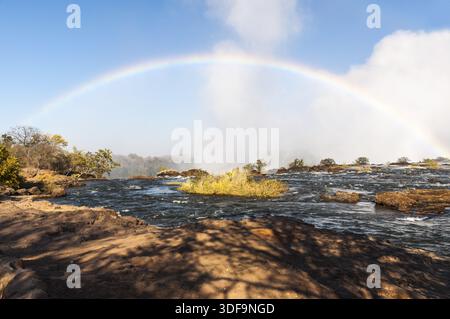 Regenbogen am frühen Morgen von der Sambia-Seite der Victoria Fälle gesehen Stockfoto