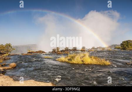 Regenbogen am frühen Morgen von der Sambia-Seite der Victoria Fälle gesehen Stockfoto