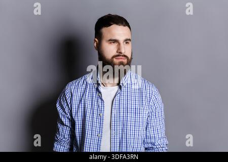 Gutaussehender nachdenklicher bärtiger Mann, der wegschaut Stockfoto