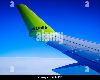 01 11 2026 - Dubai, Vereinigte Arabische Emirate. Der Blick aus dem Flugzeugfenster von airBaltic Airlines während eines Fluges. Flugzeugflügel vor blauem Himmel Stockfoto