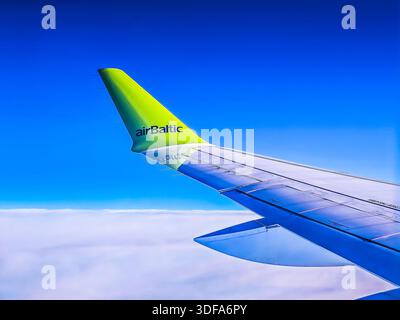 01 11 2026 - Dubai, Vereinigte Arabische Emirate. Der Blick aus dem Flugzeugfenster von airBaltic Airlines während eines Fluges. Flugzeugflügel vor blauem Himmel Stockfoto
