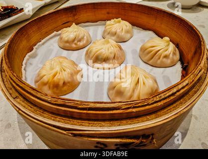 Xiao Long Bao: Traditionelle taiwanesische und chainesische gedämpfte Suppenknödel in einem hölzernen Dampfkorb in einem Restaurant Stockfoto