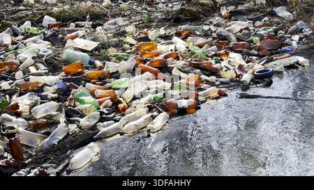 Der schmutzige Fluss ist mit vielen Plastikflaschen verschmutzt. Viel Müll wird an offenen und frei zugänglichen Plätzen in der Natur entsorgt. Globale Umwelt Stockfoto