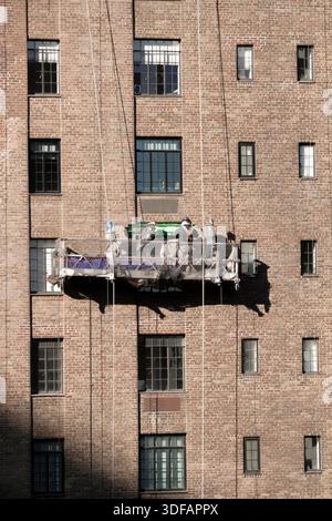 Arbeiter, die Gerüste umbauen, Ziegelfassaden umlegen, defekte Ziegelsteine und Mörtel entfernen, wie es das New York City Local Law 11 vorschreibt, das Reparaturen, regelmäßige Inspektionen und Wartung von Gebäudefassaden vorschreibt, Freitag, den 12. Dezember 2025 in New York City. Foto von Jennifer Graylock-Alamy Stockfoto