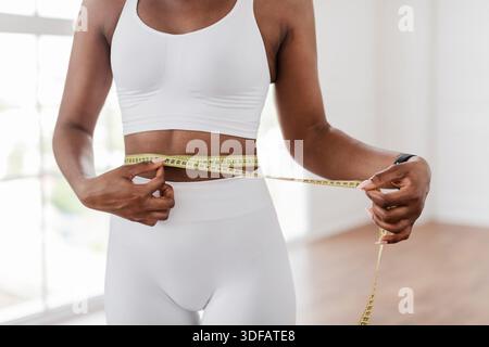 Schwarze Frau, Die Die Taille Mit Klebeband Misst. Diät Abnehmen Konzept Stockfoto