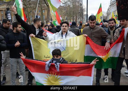 Kurdische Demonstranten halten Flaggen und Plakate während eines Protestes vor der Downing Street, die ein Ende der Angriffe auf kurdische Zivilisten in Syrien fordern Stockfoto