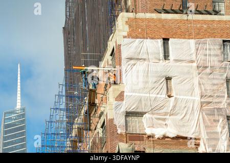 Arbeiter, die Gerüste umbauen, Ziegelfassaden umlegen, defekte Ziegelsteine und Mörtel entfernen, wie es das New York City Local Law 11 vorschreibt, das Reparaturen, regelmäßige Inspektionen und Wartung von Gebäudefassaden vorschreibt, Montag, 17. November 2025 in New York City. Foto von Jennifer Graylock-Alamy Stockfoto