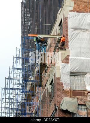 Arbeiter, die Gerüste umbauen, Ziegelfassaden umlegen, defekte Ziegelsteine und Mörtel entfernen, wie es das New York City Local Law 11 vorschreibt, das Reparaturen, regelmäßige Inspektionen und Wartung von Gebäudefassaden vorschreibt, Montag, 17. November 2025 in New York City. Foto von Jennifer Graylock-Alamy Stockfoto