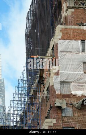 Arbeiter, die Gerüste umbauen, Ziegelfassaden umlegen, defekte Ziegelsteine und Mörtel entfernen, wie es das New York City Local Law 11 vorschreibt, das Reparaturen, regelmäßige Inspektionen und Wartung von Gebäudefassaden vorschreibt, Montag, 17. November 2025 in New York City. Foto von Jennifer Graylock-Alamy Stockfoto