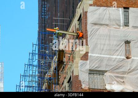 Arbeiter, die Gerüste umbauen, Ziegelfassaden umlegen, defekte Ziegelsteine und Mörtel entfernen, wie es das New York City Local Law 11 vorschreibt, das Reparaturen, regelmäßige Inspektionen und Wartung von Gebäudefassaden vorschreibt, Montag, 17. November 2025 in New York City. Foto von Jennifer Graylock-Alamy Stockfoto