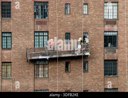 Arbeiter, die Gerüste umbauen, Ziegelfassaden umlegen, defekte Ziegelsteine und Mörtel entfernen, wie es das New York City Local Law 11 vorschreibt, das Reparaturen, regelmäßige Inspektionen und Wartung von Gebäudefassaden vorschreibt, Montag, 17. November 2025 in New York City. Foto von Jennifer Graylock-Alamy Stockfoto