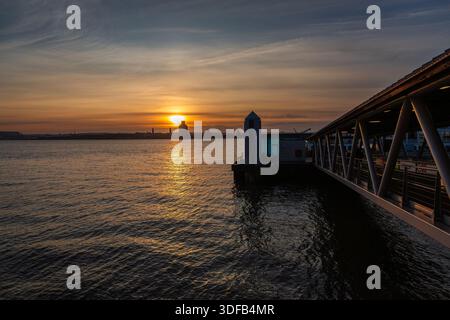 Liverpool, Großbritannien, 10. Januar 2026: Fährhafen Pier Head bei Sonnenuntergang mit Blick über den Fluss Mersey nach Birkenhead und der Halbinsel Wirral. Stockfoto
