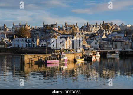 Fischerboote legen am Pier im Findochty Harbour auf dem Moray Firth of Scotland an. Die Sonne scheint an einem Wintertag, beleuchtet den Hafen und Stockfoto