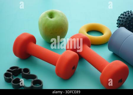 Gewichte, einen Apfel und Übungsgeräte auf einem Tisch Stockfoto