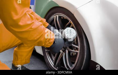 Automechaniker wechselt das Autorad in der Garage. Stockfoto