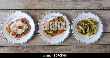 Blick von oben mit einer Vielzahl von gesunden Avocadotoasts mit Eiern, Lachs und Pilzen Stockfoto