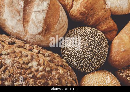 Frisch gebackenes, handwerkliches Brot in warmer Atmosphäre mit verschiedenen Texturen und Farben Stockfoto
