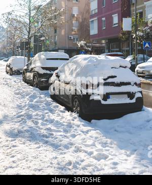 Schnee bedeckt auf städtische Straße geparkten Autos Stockfoto
