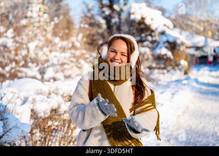 Winterporträt einer glücklichen jungen Frau in warmer Kleidung im Freien Stockfoto