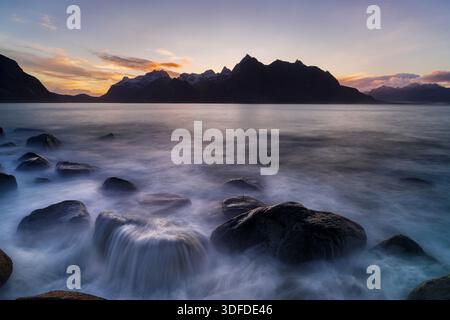 Wellen, die bei Sonnenuntergang auf Felsen krachen Stockfoto