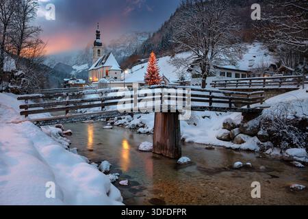 Winterwunderland in den Alpen. Bayerische Alpen zu Weihnachten, mit Pfarrkirche St. Sebastian in Ramsau bei Berchtesgaden, Deutschland bei Sonnenuntergang. Stockfoto
