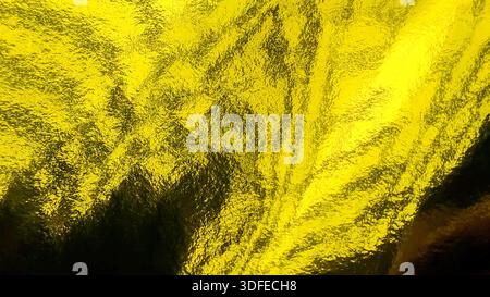Nahaufnahme der zerknitterten Gelbgold-Folienstruktur, die einen glänzenden metallischen Hintergrund für Festthemen bietet Stockfoto