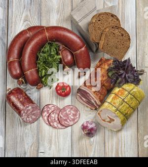 Verschiedene Arten von Würsten mit Gemüse auf einem Holztisch Stockfoto
