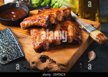 Scharfe heiße gegrillte Spare Ribs vom Sommer-BBQ serviert mit heißem Chili und frischen Tomaten Stockfoto