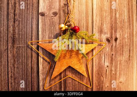 Rustikale Weihnachtsdekoration. Ein Stern im Landhausstil mit Pinienzweigen und bunten Kugeln dekoriert. Fenster-, Tür- oder Wanddekoration. Stockfoto